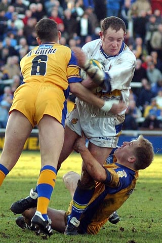 Dean Vaughan being tackled by McGuire and Burrow
